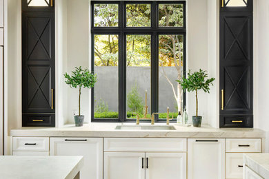 Large elegant dark wood floor kitchen photo in Dallas with recessed-panel cabinets, marble countertops, paneled appliances and an island