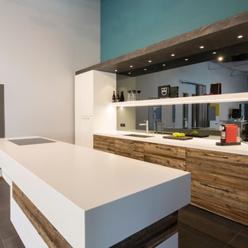 Küche mit Corian Arbeitsflächen, Altholzfronten und lackierten Türen