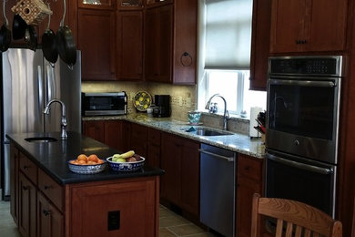 Mid-sized elegant l-shaped ceramic tile eat-in kitchen photo in Denver with shaker cabinets, dark wood cabinets, an island, granite countertops, an undermount sink, beige backsplash, cement tile backsplash and stainless steel appliances