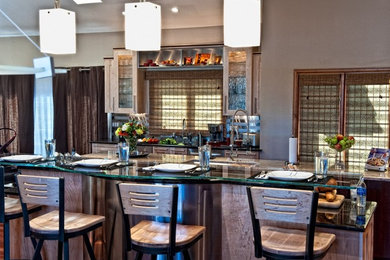 Inspiration for a contemporary single-wall medium tone wood floor eat-in kitchen remodel in Denver with an undermount sink, glass-front cabinets, light wood cabinets, granite countertops, stainless steel appliances and an island