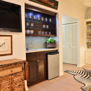 ヒューストンの大きいトラディショナルスタイルのおしゃれな着席型バー (ルーバー扉のキャビネット、濃色木目調キャビネット、人工大理石カウンター、グレーのキッチンパネル、ガラスタイルのキッチンパネル、淡色無垢フローリング) の写真