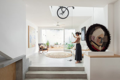 Photo of a mid-sized contemporary living room in Sydney with white walls, concrete floors, no fireplace and no tv.