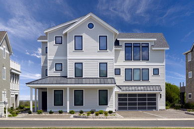 Large beach style three-storey white house exterior in Wilmington with a gable roof and a mixed roof.