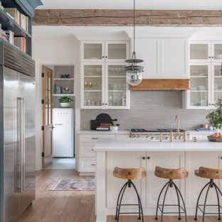 Ispirazione per una cucina tradizionale con lavello stile country, ante in stile shaker, ante bianche, top in quarzo composito, paraspruzzi grigio, elettrodomestici in acciaio inossidabile, pavimento in legno massello medio, pavimento marrone, top bianco e travi a vista