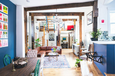 Living room - industrial light wood floor and exposed beam living room idea in Boston with blue walls