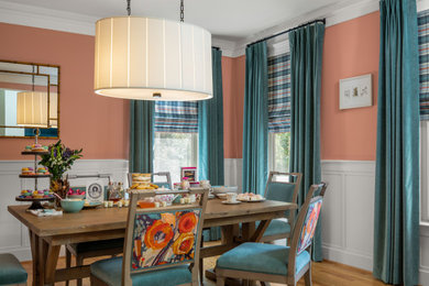 Inspiration for a transitional medium tone wood floor dining room remodel in Other with pink walls