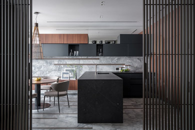 This is an example of a contemporary u-shaped eat-in kitchen in Moscow with flat-panel cabinets, black cabinets, grey splashback, stone slab splashback, a peninsula, grey floor, black benchtop and an undermount sink.