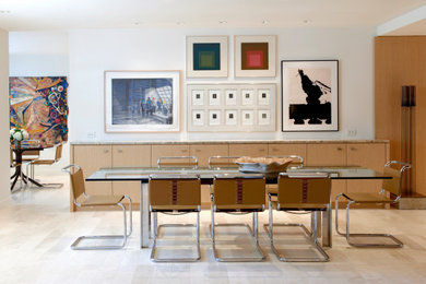 This is an example of a large contemporary dining room in Chicago with white walls, limestone floors, beige floor and panelled walls.