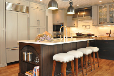 Open concept kitchen - transitional u-shaped medium tone wood floor open concept kitchen idea in New York with an undermount sink, recessed-panel cabinets, gray cabinets, quartz countertops, white backsplash, stone tile backsplash and stainless steel appliances