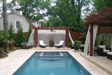 This is an example of a mid-sized traditional backyard rectangular natural pool in Atlanta with a hot tub and natural stone pavers.