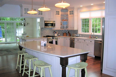 Inspiration for a mid-sized timeless u-shaped kitchen remodel in Boston with raised-panel cabinets, white cabinets, quartz countertops, glass tile backsplash and an island