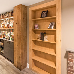 Photo of a large urban look-out basement in Chicago with grey walls, medium hardwood flooring, no fireplace and brown floors.