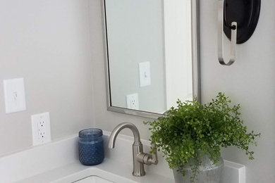 Inspiration for a mid-sized transitional master white tile and porcelain tile vinyl floor, brown floor and double-sink bathroom remodel in Kansas City with shaker cabinets, dark wood cabinets, a two-piece toilet, gray walls, an undermount sink, quartzite countertops, a hinged shower door, white countertops, a niche and a built-in vanity