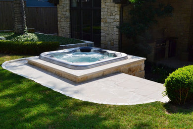 This is an example of a large arts and crafts backyard patio in Austin with a water feature and no cover.