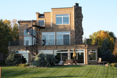 Large transitional beige three-story stucco exterior home photo in Minneapolis