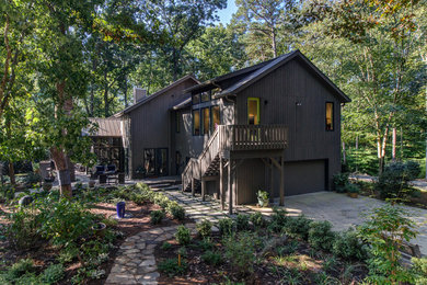 Mid-sized modern brown two-story wood house exterior idea in Raleigh with a clipped gable roof and a metal roof