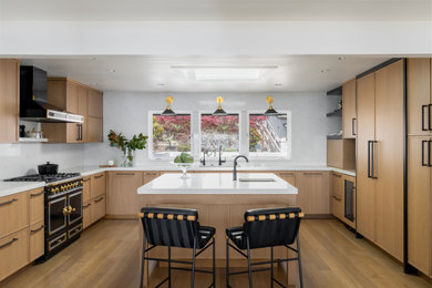 Inspiration for a large contemporary u-shaped medium tone wood floor, brown floor and shiplap ceiling eat-in kitchen remodel in Seattle with an undermount sink, flat-panel cabinets, light wood cabinets, quartz countertops, white backsplash, quartz backsplash, paneled appliances, an island and white countertops