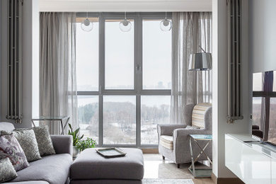 Стильный дизайн: открытая гостиная комната среднего размера в стиле неоклассика (современная классика) с серыми стенами, паркетным полом среднего тона, телевизором на стене и коричневым полом - последний тренд