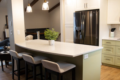 Kitchen - mid-sized transitional laminate floor, brown floor and vaulted ceiling kitchen idea in Other with an undermount sink, recessed-panel cabinets, white cabinets, quartz countertops, beige backsplash, mosaic tile backsplash, black appliances, an island and white countertops