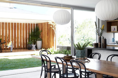 Photo of a mid-sized contemporary kitchen/dining combo in Sydney with concrete floors and white walls.
