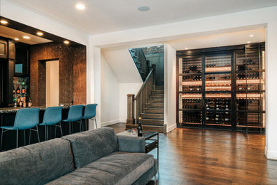 Photo of a small contemporary wine cellar in Portland with dark hardwood floors, display racks and brown floor.
