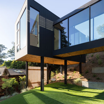 Cantilevered ADU wing on black steel columns with cedar soffit