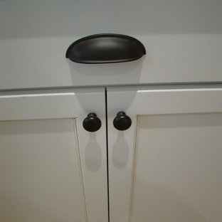 Klassisk inredning av ett stort kök, med skåp i shakerstil, vita skåp, granitbänkskiva, vitt stänkskydd, stänkskydd i tunnelbanekakel, en trippel diskho, vita vitvaror och mellanmörkt trägolv