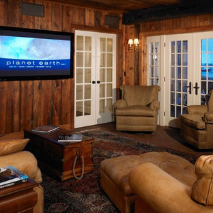 Cette photo montre une salle de cinéma bord de mer de taille moyenne et fermée avec un mur marron, un sol en brique et un téléviseur fixé au mur.