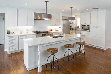 Inspiration for a large contemporary open plan kitchen in Denver with a double-bowl sink, shaker cabinets, white cabinets, quartzite benchtops, white splashback, subway tile splashback, stainless steel appliances, dark hardwood floors, with island and brown floor.