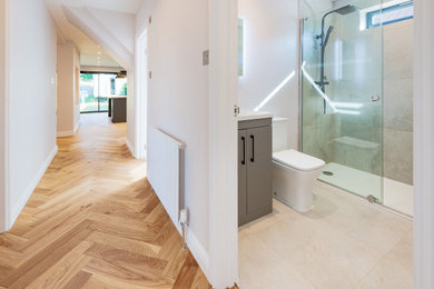 Design ideas for a medium sized contemporary bathroom in Surrey with flat-panel cabinets, grey cabinets, a walk-in shower, ceramic tiles, grey walls, ceramic flooring, grey floors, a sliding door, grey worktops, a wall niche, a single sink and a freestanding vanity unit.