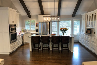 Example of a large transitional u-shaped dark wood floor and brown floor eat-in kitchen design in Kansas City with an undermount sink, recessed-panel cabinets, white cabinets, quartz countertops, gray backsplash, stone slab backsplash, stainless steel appliances, an island and gray countertops