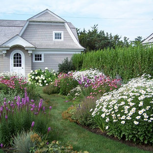 Idées déco pour un jardin à la française arrière bord de mer l'été avec une exposition ensoleillée.