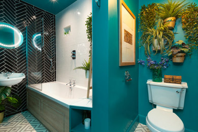 Design ideas for a mid-sized eclectic kids bathroom in Edinburgh with a drop-in tub, a shower/bathtub combo, a one-piece toilet, black and white tile, ceramic tile, green walls, linoleum floors, a wall-mount sink, tile benchtops, grey floor, a hinged shower door and white benchtops.