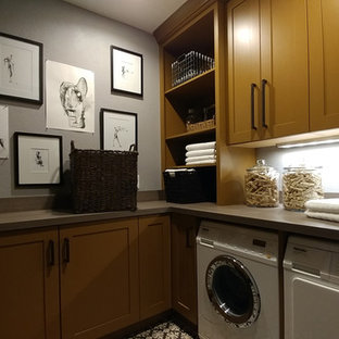 Modelo de cuarto de lavado en U, tradicional renovado, pequeño, con armarios con paneles lisos, puertas de armario amarillas, encimera de laminado, paredes grises, suelo de baldosas de cerámica, lavadora y secadora juntas, suelo gris y encimeras grises