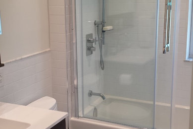 Inspiration for a small modern master gray tile and mosaic tile marble floor bathroom remodel in Toronto with flat-panel cabinets, dark wood cabinets, a one-piece toilet, white walls, an integrated sink and quartzite countertops