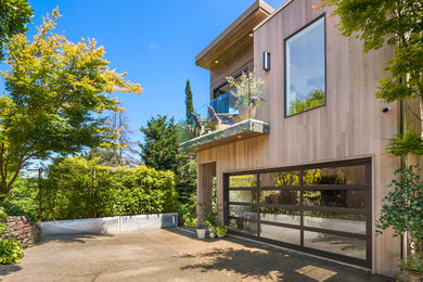 This is an example of a mid-sized contemporary three-storey white house exterior in Seattle with wood siding and a flat roof.