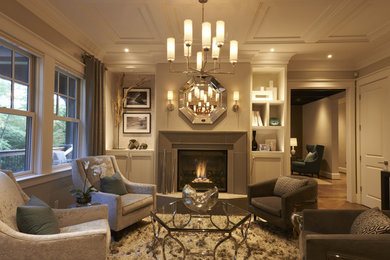 Example of a mid-sized trendy enclosed medium tone wood floor living room design in Other with beige walls, a standard fireplace and no tv