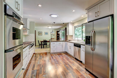 Example of a mid-sized trendy u-shaped kitchen pantry design in Seattle with a double-bowl sink, shaker cabinets, gray cabinets, quartz countertops, white backsplash, ceramic backsplash, stainless steel appliances and a peninsula