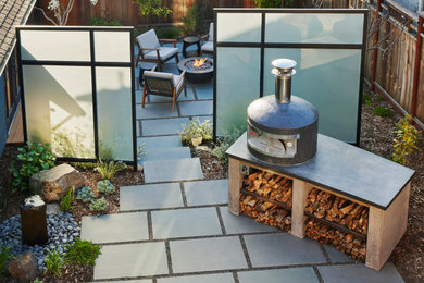 Inspiration for a mid-sized modern backyard stone patio remodel in San Francisco with a fire pit