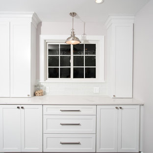 Inspiration for a modern u-shaped kitchen pantry in Detroit with recessed-panel cabinets, white cabinets, quartzite benchtops, white splashback, cement tile splashback, stainless steel appliances and with island.
