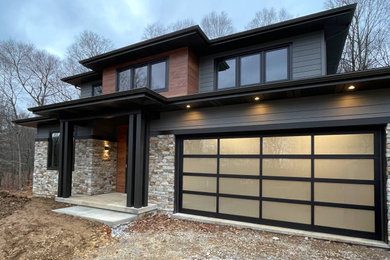 Inspiration for a modern two-story mixed siding house exterior remodel in Other with a hip roof