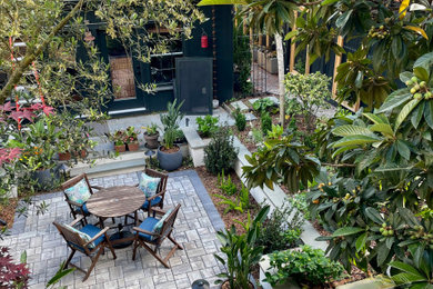 Patio fountain - mid-sized modern courtyard stone patio fountain idea in Other