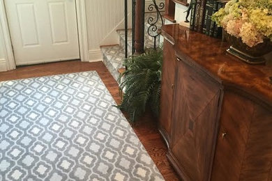 Mid-sized trendy dark wood floor entryway photo in New York with gray walls and a white front door