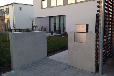 Sichtbeton-Mauerscheiben mit Gartentür und Briefkasten