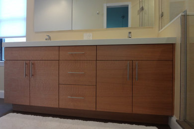 Bathroom - mid-sized contemporary porcelain tile bathroom idea in DC Metro with an integrated sink, furniture-like cabinets, medium tone wood cabinets, solid surface countertops and yellow walls