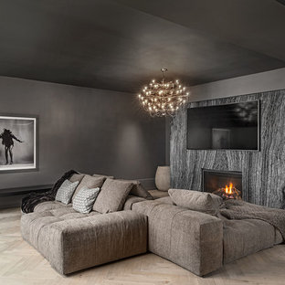 Design ideas for a mediterranean basement in Toronto with black walls, light hardwood flooring, a standard fireplace, a stone fireplace surround and beige floors.