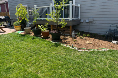 Large backyard ground level mixed material railing deck photo in Denver