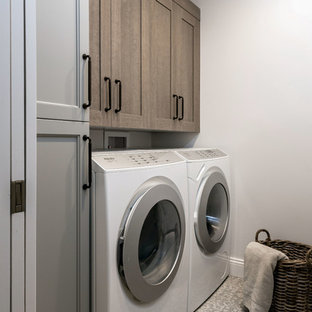 サンフランシスコの中サイズのおしゃれな家事室 (ドロップインシンク、ガラス扉のキャビネット、中間色木目調キャビネット、クオーツストーンカウンター、白い壁、セラミックタイルの床、左右配置の洗濯機・乾燥機、マルチカラーの床、白いキッチンカウンター) の写真