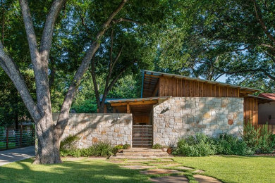 Small trendy one-story stone exterior home photo in Austin with a shed roof
