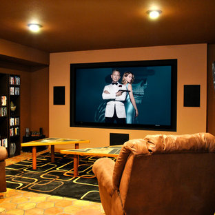 Exemple d'une grande salle de cinéma montagne fermée avec un mur orange, un sol en carreau de terre cuite, un écran de projection et un sol orange.